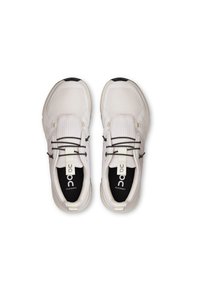 Scarpe da ginnastica bianche con superiore in rete testurizzata, accenti neri, lacci elastici e suole imbottite. Loghi visibili su entrambe le scarpe.