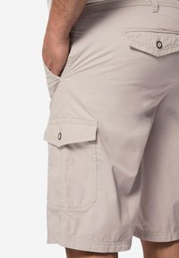 Helle graue Cargo-Shorts aus einem Baumwoll-Mischgewebe. Zu den Merkmalen gehören Seiten- und Gesäßtaschen mit Knopfverschluss sowie flache Nähte.