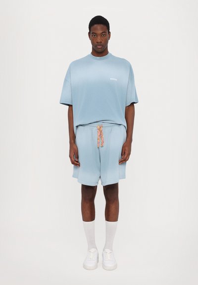 Lichtblauw katoenen T-shirt met een relaxed fit en korte mouwen, gecombineerd met bijpassende katoenen shorts met een kleurrijke koord en zakken.