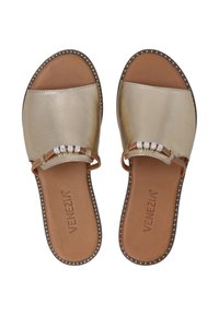 Guldmetallic slidesandal med en bred rem med perleaccentuer og en brun læderfodseng. Kantet med en kontrasterende studset kant.