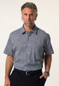 Lyhythihainen napillinen paita tummansinistä, teksturoitua kangasta, jossa on hillitty kuvio. Klassinen kaulus ja valkoiset napit.