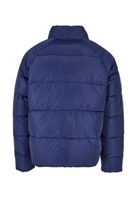 Navy blue puffer jacket with a high collar, quilted design, and horizontal seams. Smooth, shiny fabric with a lightweight appearance.