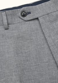 Grå teksturerede stofbukser med knaplukning, der har en glat front og en kontrasterende marineblå linning.