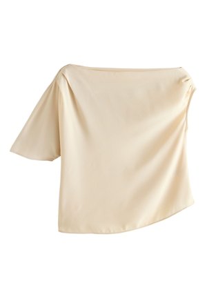 Blouse en satin beige asymétrique avec une manche courte à gauche et un large col bateau, texture lisse et coupe ample.