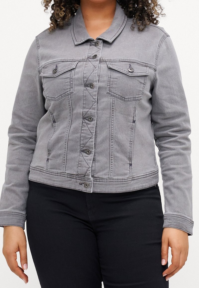 Šedá džínová bunda s dlouhými rukávy, zapínáním na knoflíky, dvěma náprsními kapsami a úzkým střihem, s jemnými detaily šití.