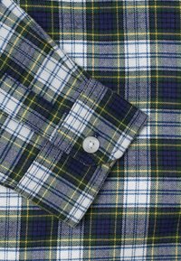 Camicia di flanella con un motivo a quadri verde, bianco e navy, arricchita da dettagli gialli. Materiale in cotone con dettaglio a bottoni sui polsini.