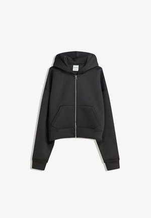 Hanorac scurt, negru, fabricat dintr-un material moale, cu fermoar frontal, buzunare mari în față și glugă. Are manșete ribbate pentru un fit confortabil.