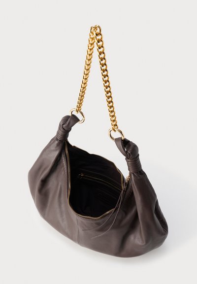 Μαλακή τσάντα χειρός από σκούρο καφέ δέρμα με χρυσή αλυσίδα, δεμένους χειρολαβές και ανοιχτό φερμουάρ που αποκαλύπτει εσωτερική τσέπη και φόδρα.