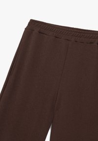 Brown elastic waistband broek met een gladde textuur, voorzien van twee zijzakken en een rechte pasvorm. Casual stijl, zonder zichtbare patronen.
