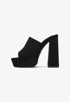 Czarne zamszowe mules na platformie z wysokim, masywnym obcasem, z szerokim, odkrytym noskiem i gładką fakturą, zaprojektowane dla stabilności i wsparcia.