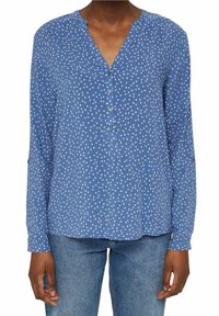 Camicia blu a maniche lunghe con scollatura a V, caratterizzata da pois bianchi, dettagli con bottoni sul davanti e una vestibilità rilassata.