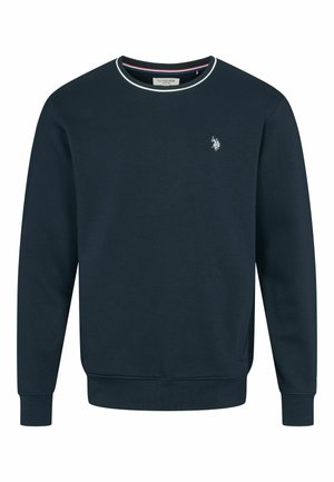 Uomo che indossa una felpa a maniche lunghe blu navy e pantaloni abbinati, con un piccolo logo bianco sul petto e sui pantaloni.