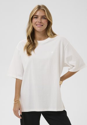 T-shirt blanc en coton oversize avec manches courtes et petit détail en forme de cœur à finition texturée sur la poitrine.