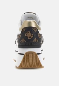 Sneaker in bianco e nero con accenti dorati, materiale testurizzato, dettagli del logo in evidenza e un design del retro a motivo. Suola in gomma rigata.