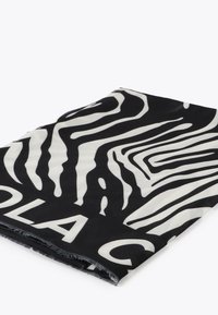 Schwarzer Stoff mit weißen Zebramustern und auffälligen Buchstaben. Der Textil hat eine weiche Textur und fransige Kanten.