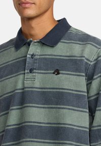 Gestreiftes Poloshirt in Grün und Marineblau, mit Kragen, drei Knöpfen und einem gestickten Pferdelogo auf der Brust. Weicher, strukturierter Stoff.