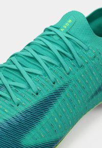 Τουρκουάζ αθλητικό παπούτσι με υφασμάτινη επένδυση, επίπεδα κορδόνια και σχέδιο με γκράντεντ σε μπλε και κίτρινες αποχρώσεις. Ελαφρύ υλικό.