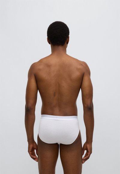 Λευκά βαμβακερά εσώρουχα με ελαστική μέση, φαινομενικά από πίσω. Ομαλή υφή, εφαρμοστό σχέδιο, μινιμαλιστικό στυλ, χωρίς σ�χέδια.