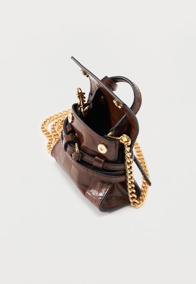 Μικρή σκούρα καφέ τσάντα με υφή κροκόδειλου, με χρυσή αλυσίδα ιμάντα, κλείσιμο με καπάκι και ανοιχτό εσωτερικό ορατό σε λευκό φόντο.