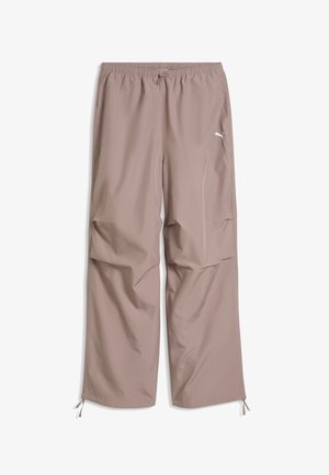 Pantaloni marrone chiaro a gamba larga con fascia elastica in vita, coulisse in vita e orli, tasche laterali e logo Puma sulla coscia destra.
