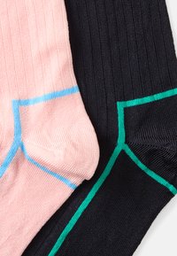 Sarkanas un tumši zilas ribotās zeķes. Ar gaiši zilu un zaļu akcentu pie aprocēm. Mīksta tekstūra, kontrastējošas krāsas un tīrs dizains.