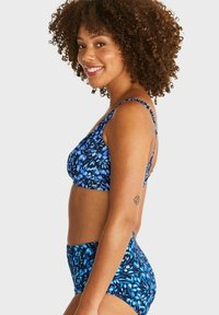 Blå blommig bikini-set med en figurnära bralette-top med justerbara band och högmidjade trosor med liknande mönster.