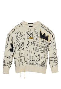 Krämsfärgad tröja med svarta graffitistilsmönster och gula detaljer. Den har en rund hals och ribbad mudd och nederkant.