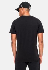 Mustat lyhythihaiset t-paidat, sopiva malli, suloinen puuvillakangas, pyöreä pääntie, yksinkertainen selkä, yhdistetty mustan lippiksen kanssa.