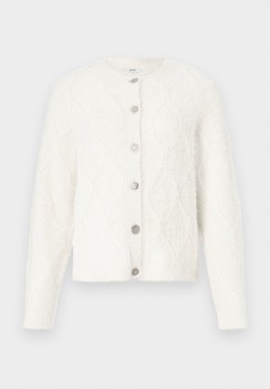 Vit fluffig stickad cardigan med långa ärmar, diamantmönster och sex dekorativa silverknappar längs mitt fram.