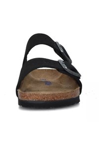 Sandali neri in suede con due cinturini regolabili e fibbie in argento, un plantare in sughero e una suola in gomma nera texturizzata.