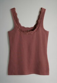 Prsníkový vršok v prachovej ružovej farbe s čipkovaným lemom na výstrihu. Nastaviteľné ramienka a priamy strih navrhnutý pre pohodlie a ľahkosť.