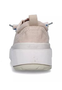 Sneaker beige con tomaia in tessuto testurizzato, suola spessa bianca, lacci blu a contrasto e una linguetta sul retro. Logo visibile sul tallone.