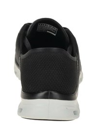 Scarpa sportiva nera con una parte superiore in rete testurizzata, colletto imbottito e suola in gomma trasparente. Presenta un branding minimale sul lato.