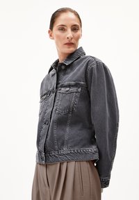 Dunkelgraue Jeansjacke mit einem Kragenhals, vorderem Knopfverschluss und zwei Brusttaschen. Sie hat eine lockere Passform und eine ausgewaschene Textur.
