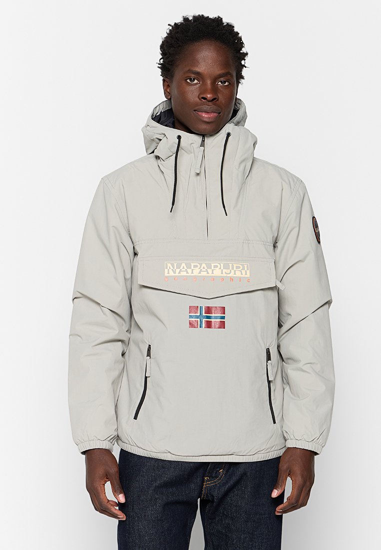 Veste à capuche gris clair avec poches zippées à l'avant et un grand logo. Présente un petit détail du drapeau de la Norvège et des poignets élastiques.