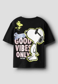 Mustasta puuvillaisesta t-paidasta löytyy Snoopy ja Woodstock -kuviot sekä rohkealla pastellisävyllä ja ääriviivoilla koristeltu "GOOD VIBES ONLY" -teksti. Lyhyet hihat.