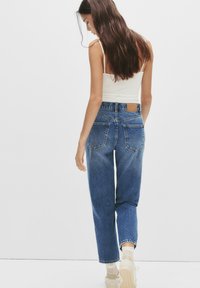 Hooggewaiste, rechte jeans in middelblauwe denim, met een leren label op de achterkant, voor- en achterzakken en subtiele wassing.