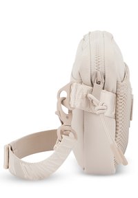 Borsa beige con zip, in tessuto testurizzato, tracolla regolabile e accessori a clip; forma compatta con accenti lisci e pattern.