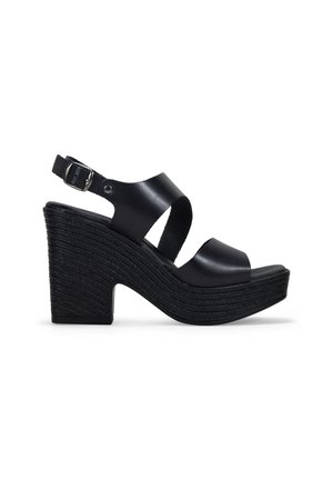 Sandalias cuña negras con parte superior de cuero. Las características incluyen tiras anchas, un hebilla ajustable en el tobillo y una plataforma texturizada con estrías horizontales.