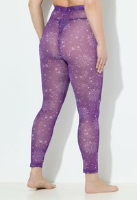 Leggings violets avec une finition translucide, ornés d'un motif de soleil et de lune en blanc. Le design comprend des étoiles et une silhouette ajustée.