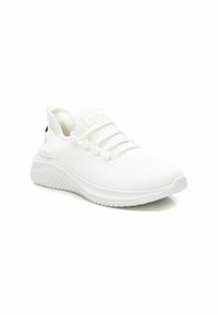 Zapatilla deportiva blanca con una parte superior de malla texturizada, diseño con cordones y una suela flexible y acanalada. Presenta un logotipo en la lengüeta y en el lateral.
