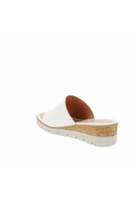Chaussure à glissière en cuir blanc avec un dessus lisse, une semelle intermédiaire texturée en liège et une semelle en caoutchouc légèrement surélevée. Design à dos ouvert pour une facilité de mise en chaussure.