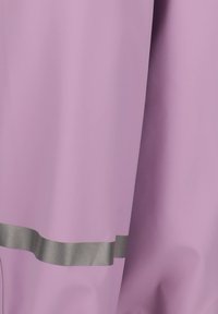 Tissu imperméable rose avec une texture lisse, présentant une rayure argentée horizontale près du bas. Design simple et fluide sans matériel visible.