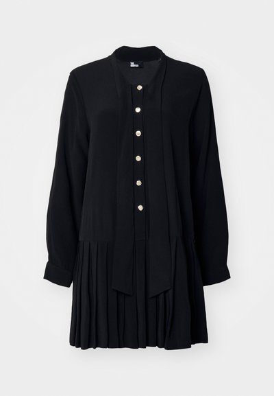 Robe noire en tissu lisse, avec des manches longues, un devant boutonné avec des boutons dorés, et un design de jupe plissée.