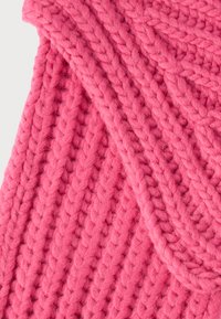 Țesătură groasă tricotată roz cu un model texturat, având detalii împletite și un aspect moale, pufos.