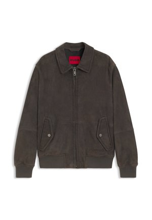 Donkerbruine suède bomberjack met ritssluiting aan de voorkant, klepzakken met knopen, geribbelde boorden en zoom, en een rood binnenlabel met de tekst "HUGO".