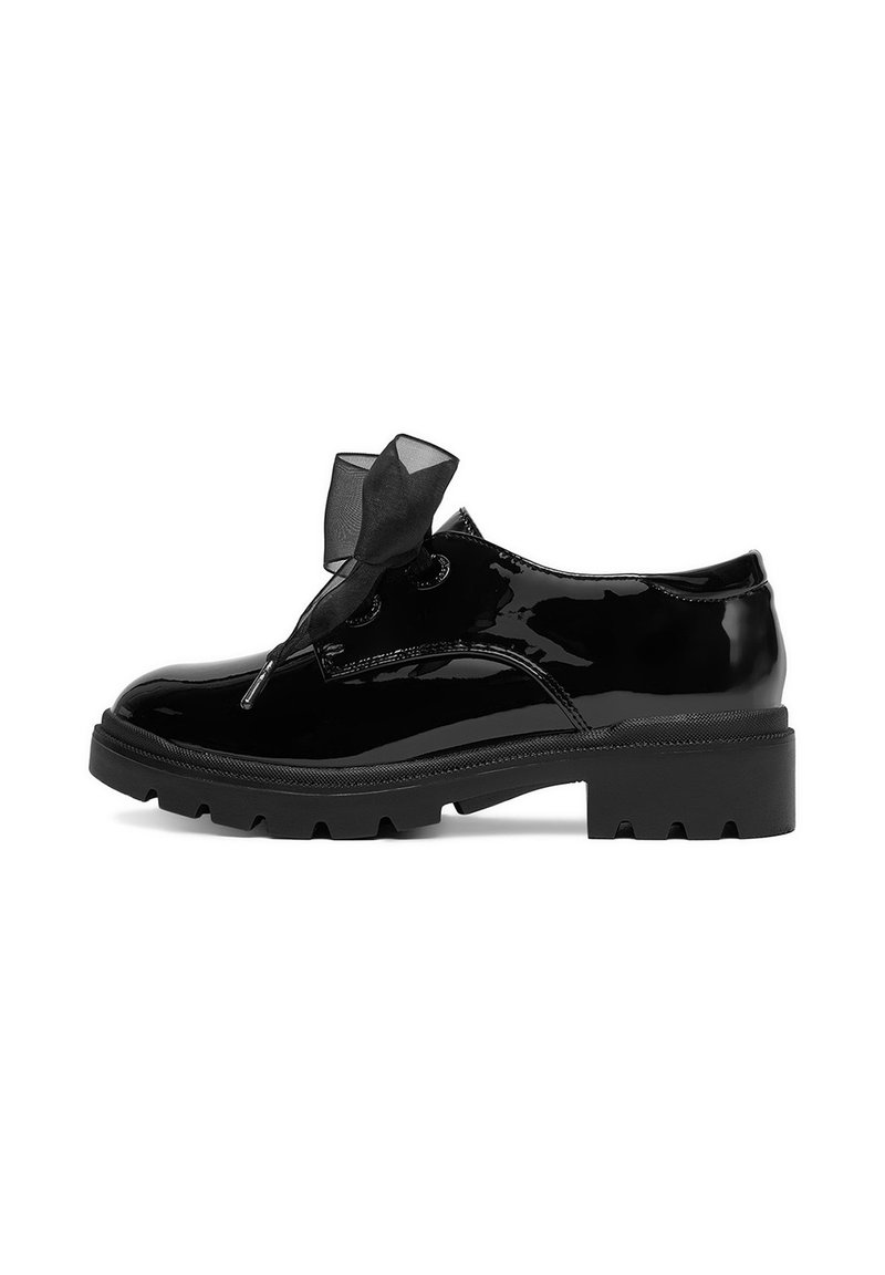 Zapatos de charol negro con puntera redondeada, suela gruesa y un lazo decorativo negro sobre los cordones. Suela gruesa con dibujo para mayor tracción.