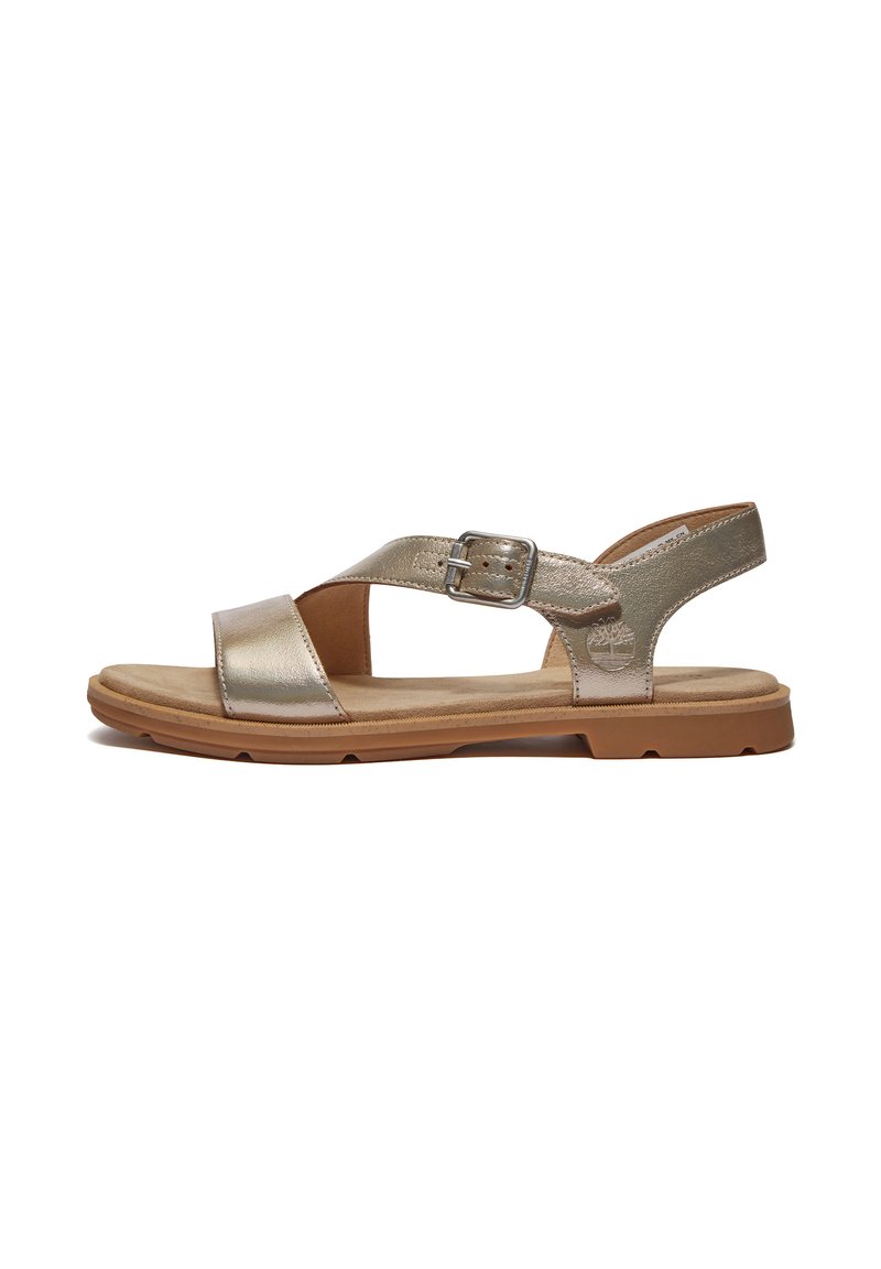 Metalliska guld-sandaler med platt sula, justerbar spänne och öppen tå-design. Mjuk mockaliknande innersula och texturerad gummiyttersula.