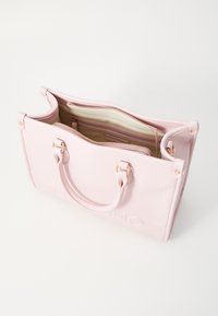 Bolsa de mão de couro texturizado rosa com duas alças, fecho com zíper e compartimentos interiores. Apresenta logotipo em relevo e ferragens em tom dourado.