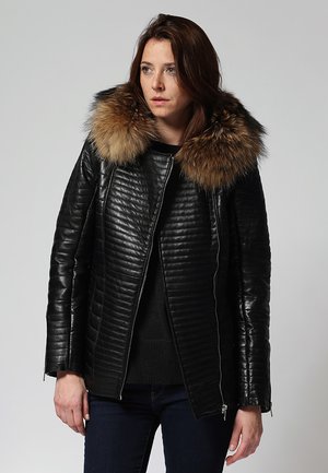 Black leather jacket with a quilted design, featuring a plush brown fur collar and a front zipper. Textured texture with side pockets.